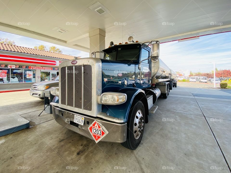 Tanker truck delivering fuel to gas station