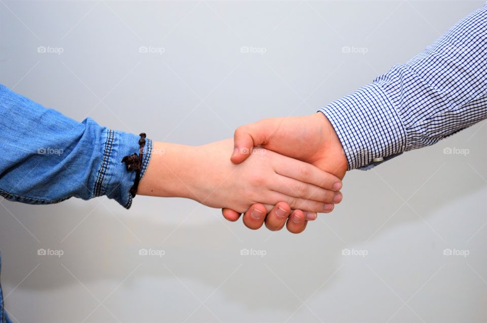 Holding hands against grey background