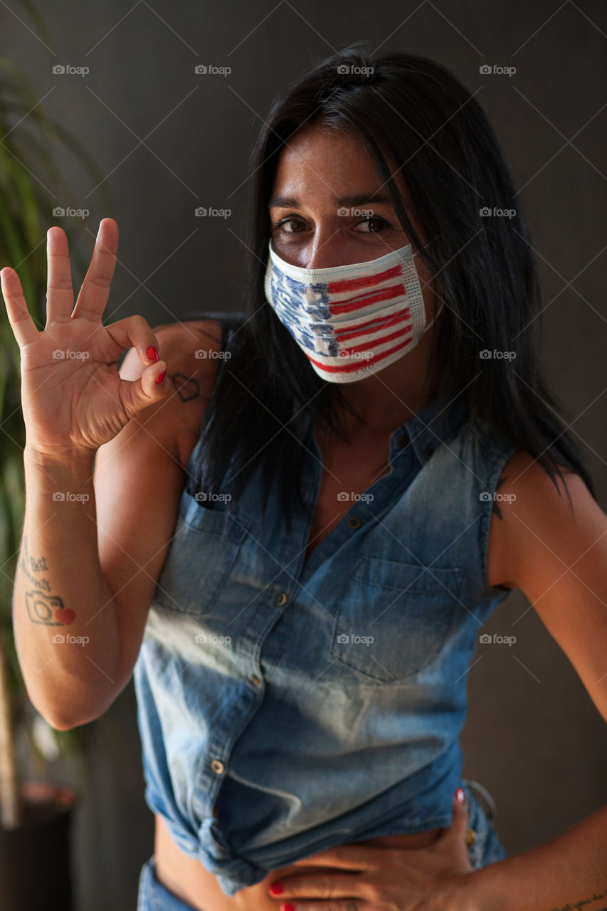 Beautiful brunette in a protective mask painted by the American flag.  Independence Day in America.  Flag.  Love.  A life.  The mask is made by hand