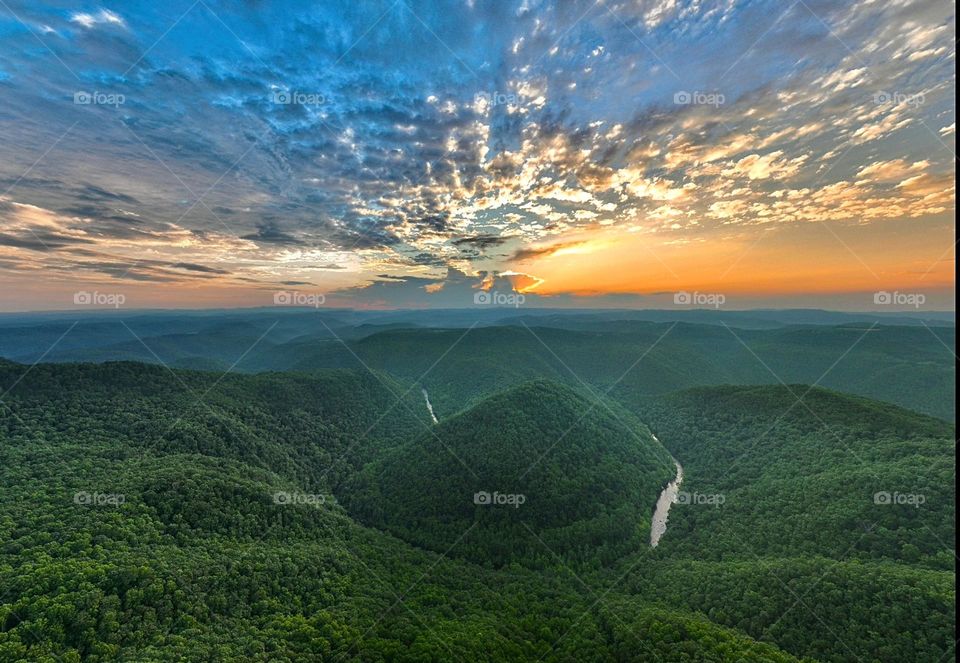 Captivating the enchanting colors of dusk with a Birds Eye view as the bluestone river weaves its way beneath the majestic mountains at Pipestem State Resort. Nature's symphony in perfect harmony.