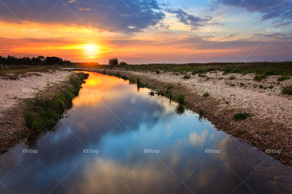 River with reflection of sunset sunrise blue and orange. Golden hour
