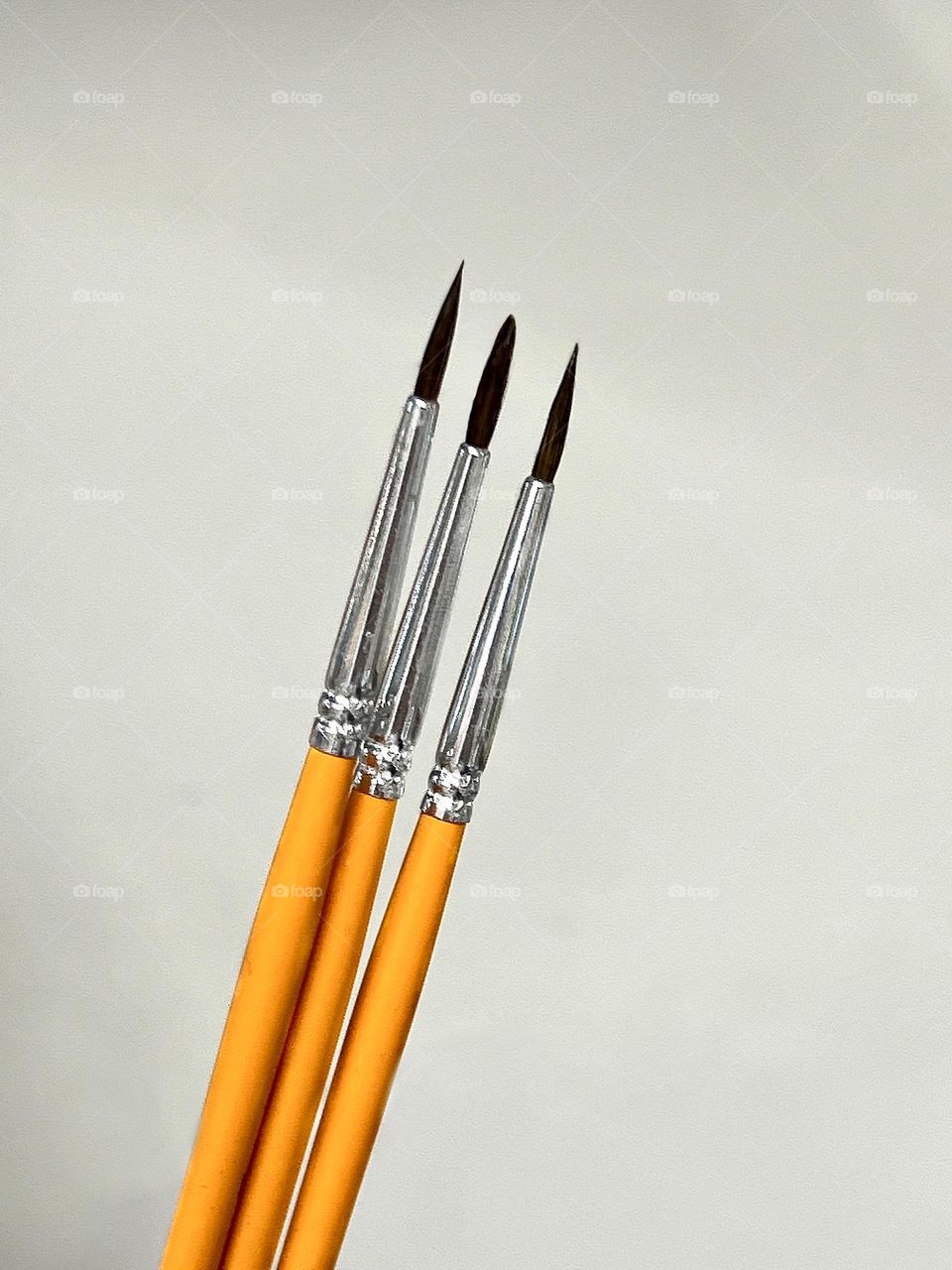 Paint brushes of different sizes on a gray background