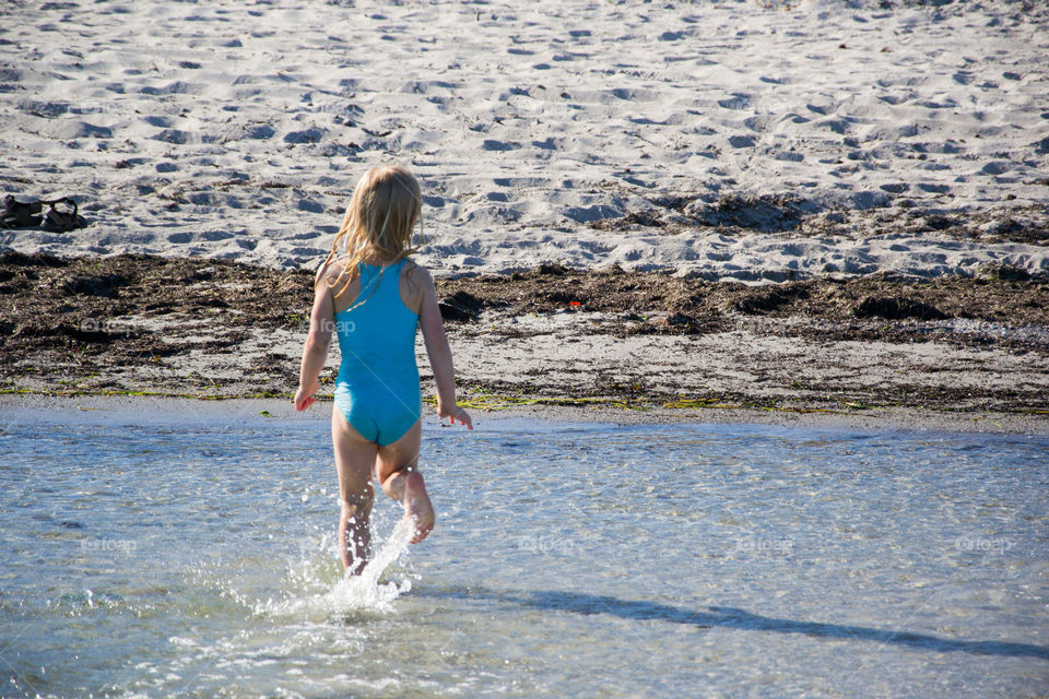 Two young sisters age five and three playing on the beach in Höllviken in Sweden.