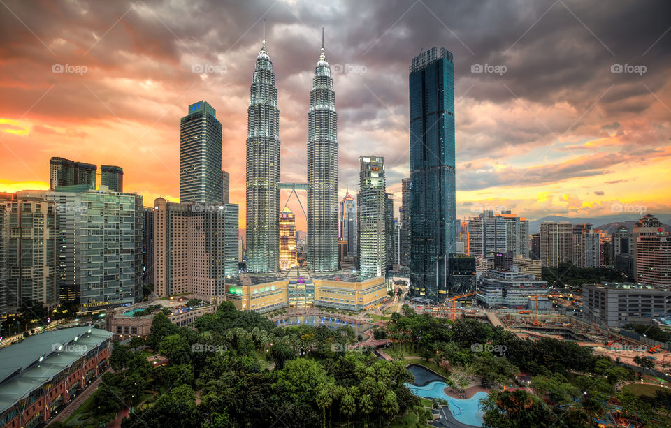 The twin Petronas towers lit up under a Kuala Lumpur sunset