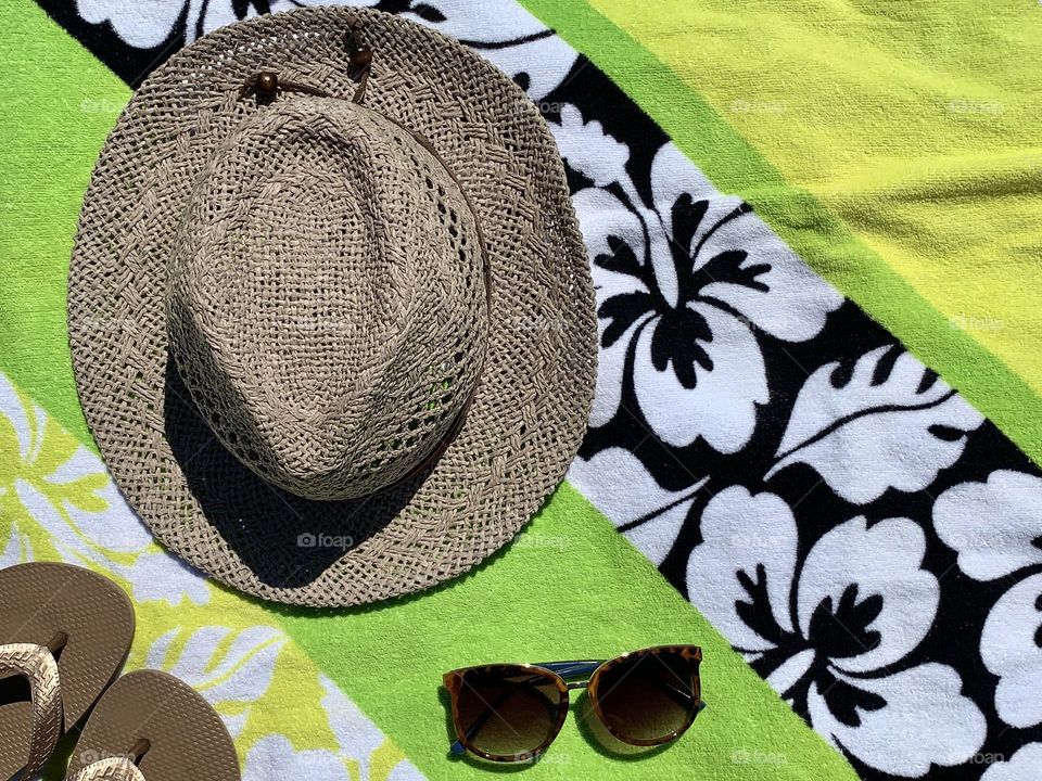 Hat, sleeper and sunglasses with colorful towel background