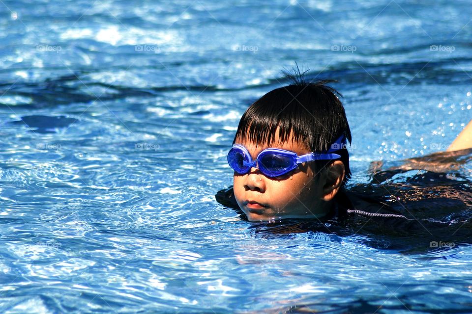 young kid swimming in a swimming pool