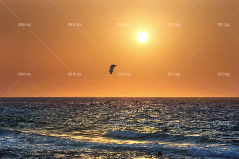 Surfing at sunset time