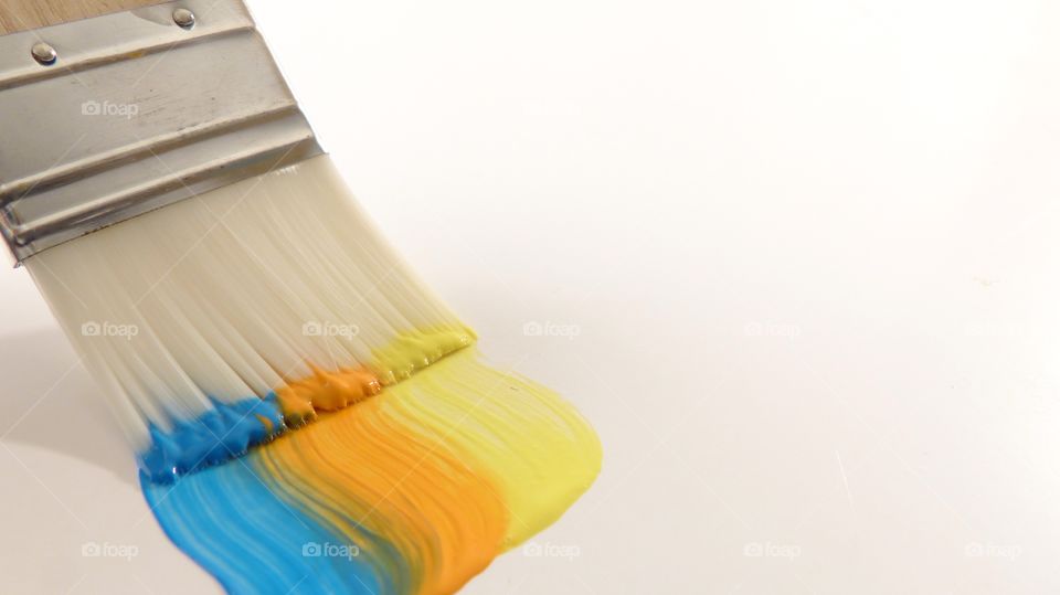 Three colors of paint on paint brush