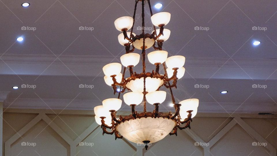 Portrait of a classic style indoor chandelier with many lights arranged upwards, the chandelier is suitable for the interior of a living room or family room.