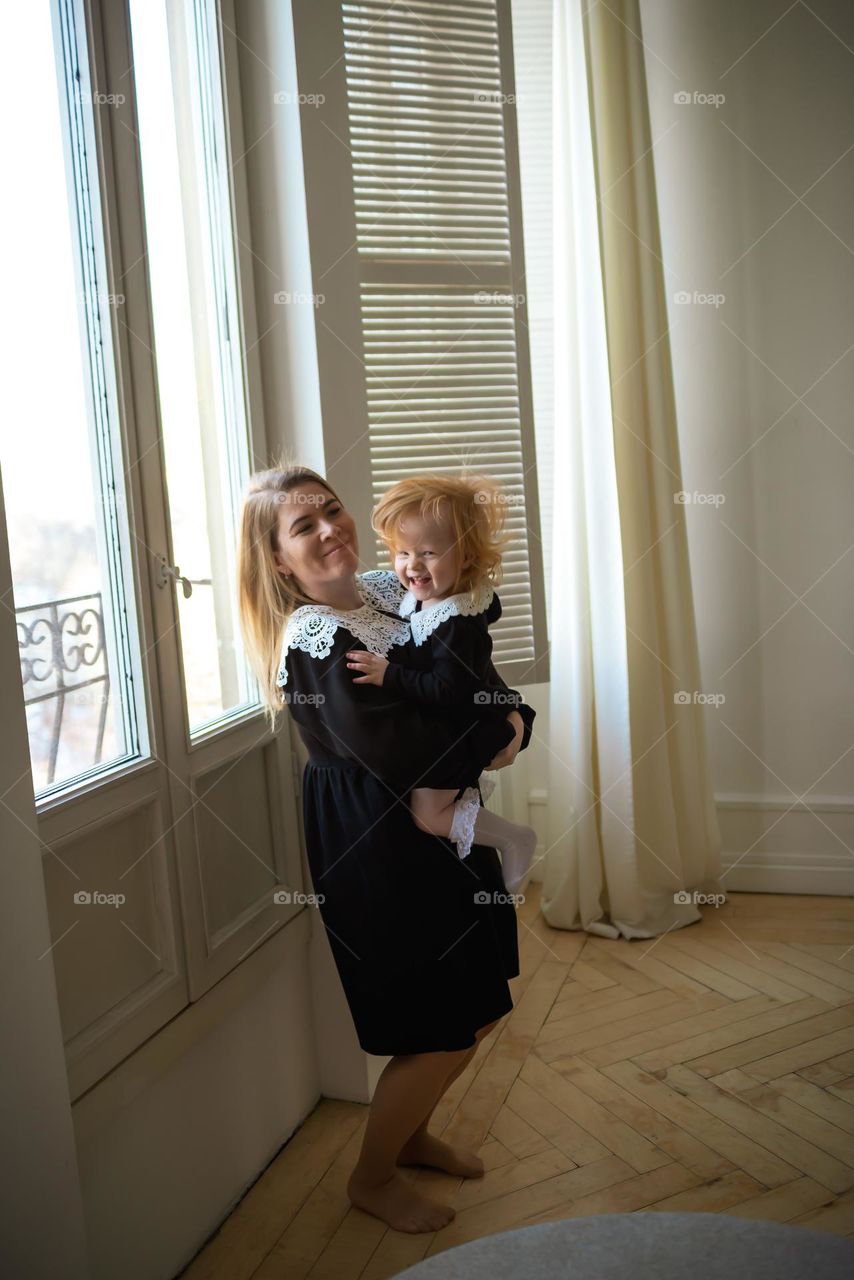 Beautiful woman mom and fun baby near the window 