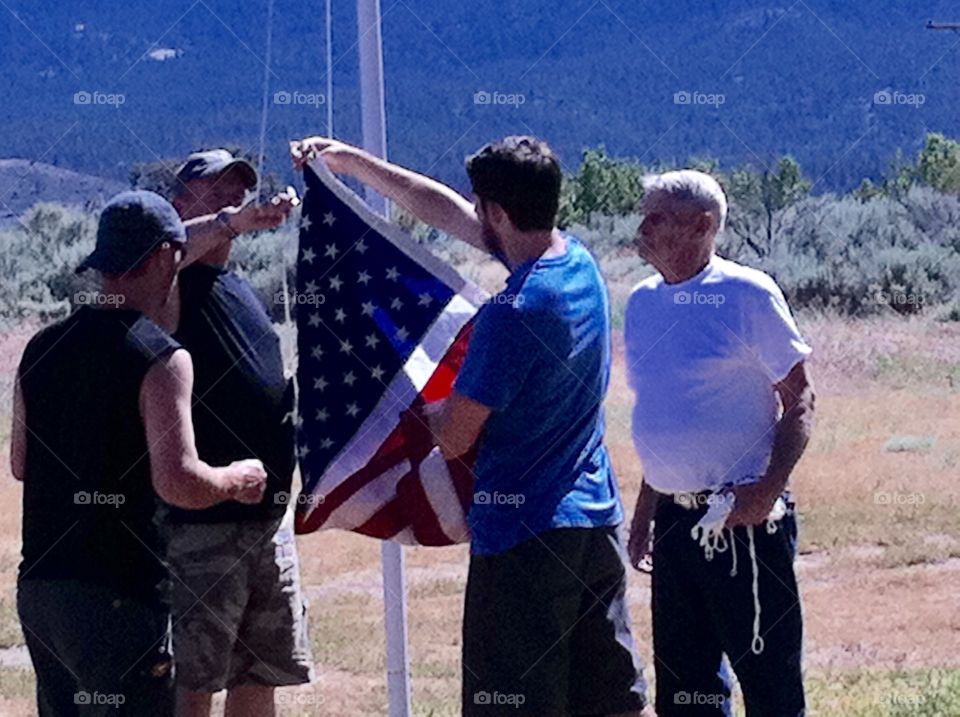 Grampa/Son in Law/Son/Grandson & boy friend  of daughter raising the flag together on the 4th of July