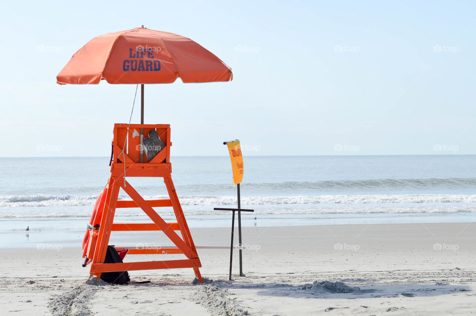 Empty lifeguard chair on the shore of the beach 