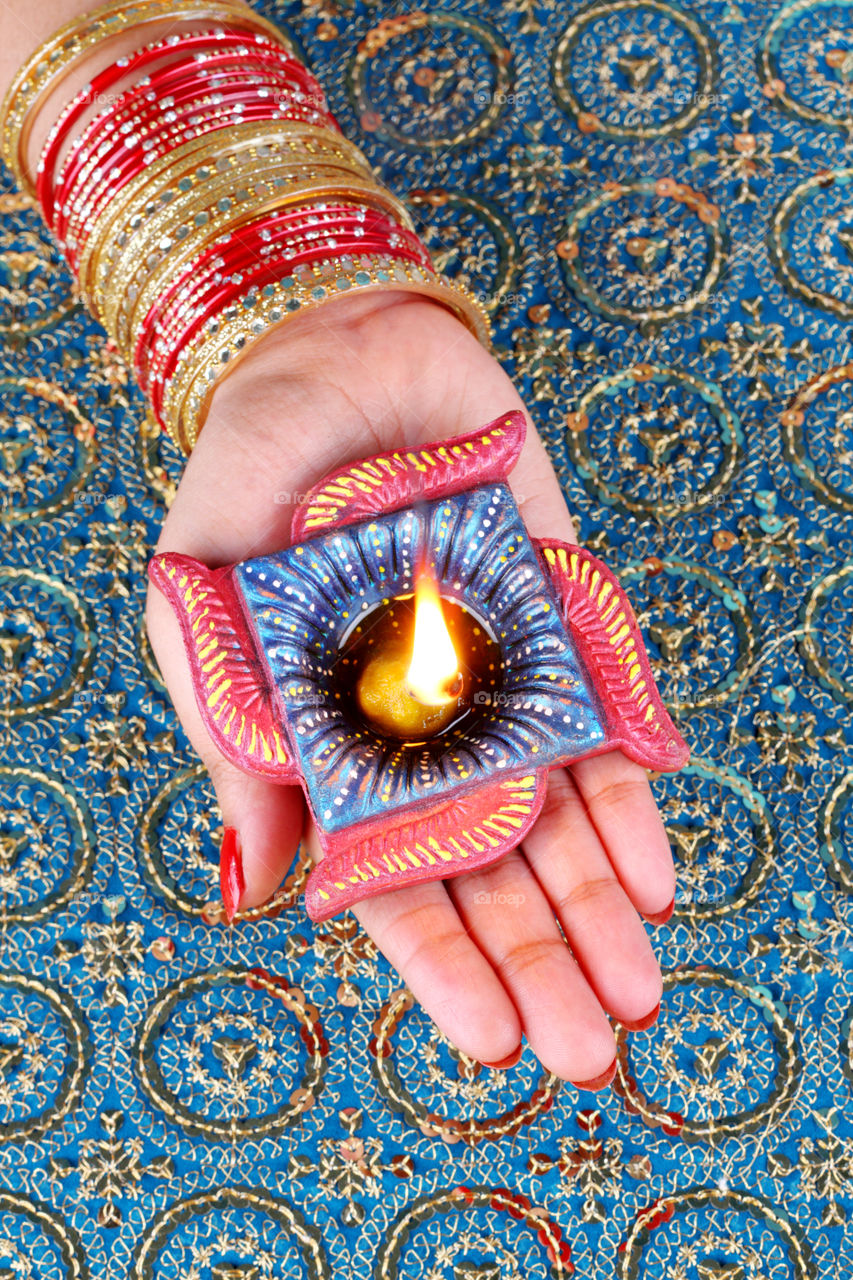 Indian festival Diwali diya in a female hand