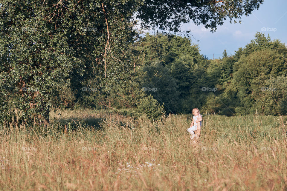 Family spending time together on a meadow, close to nature. Parents and children sitting and playing on a blanket on grass. Candid people, real moments, authentic situations