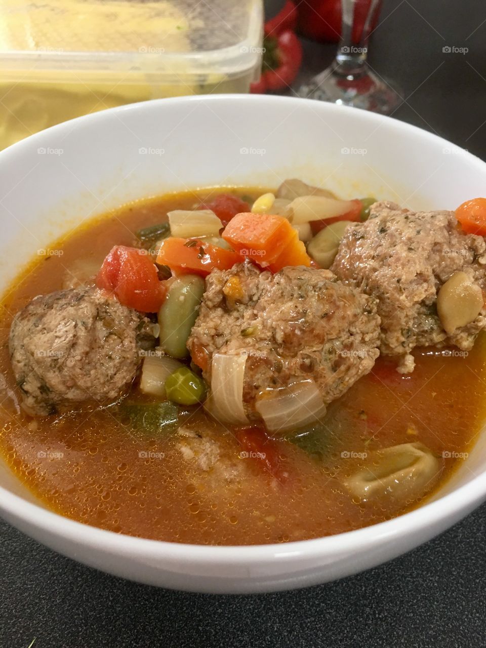 Turkey meatball vegetable soup, in white bowl, steaming closeup food