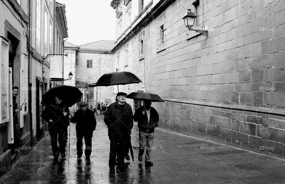 Brave old pilgrims walking in the streets of Santiago de Compostela.  Galicia, Spain.