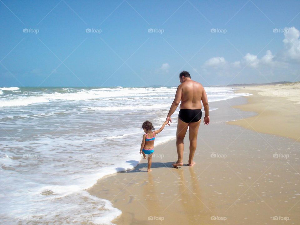 Father and daughter walking on the beach