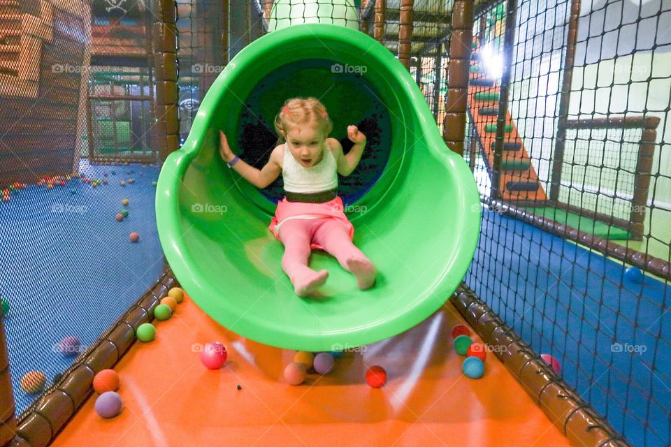 Young girl riding a slide