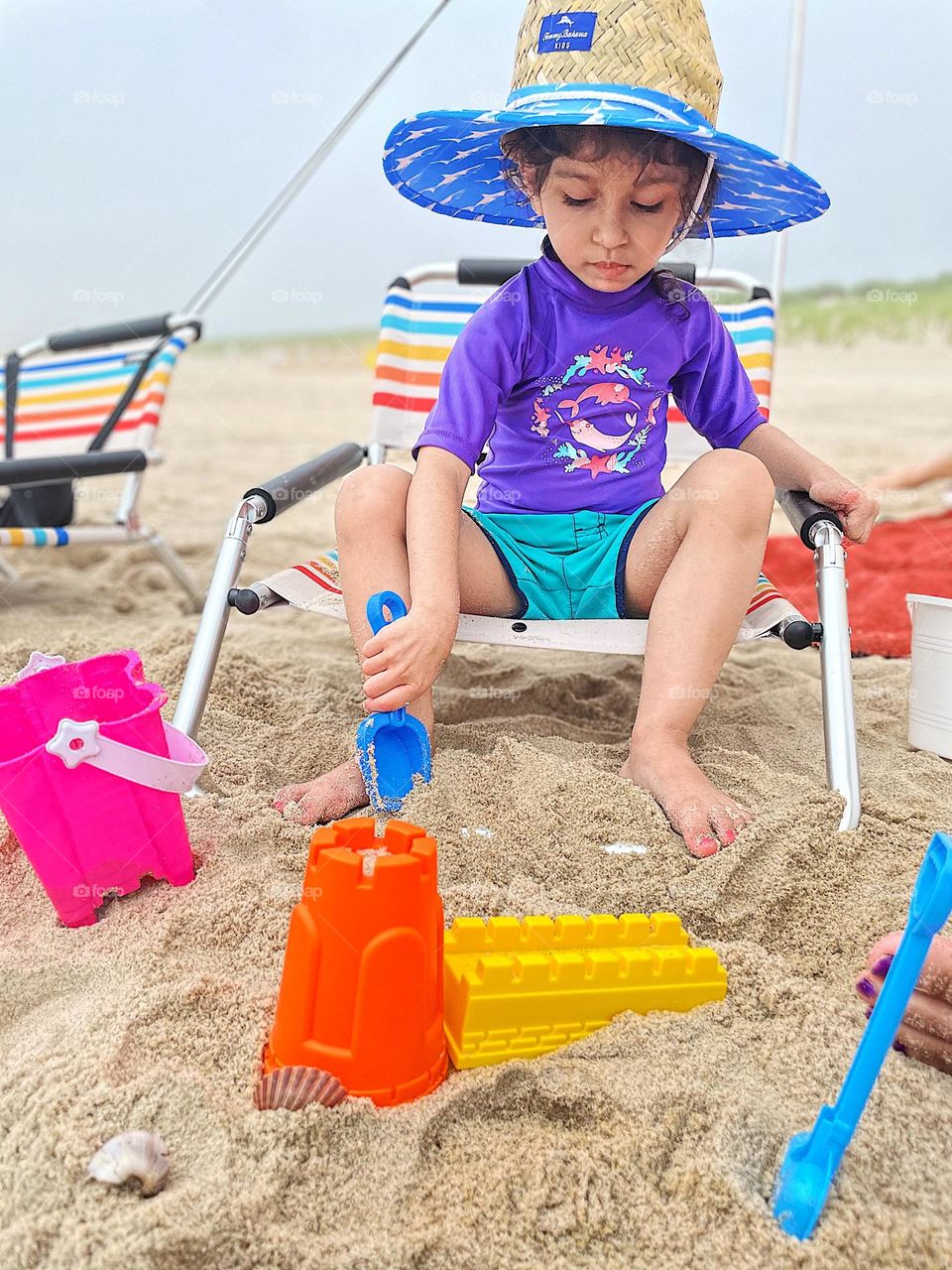 Child builds sand castles at the beach, making sand castles, long Island sand castle building, small child at the beach, making memories at the beach