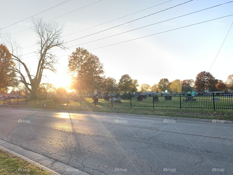 The sun rises over the local cemetery, on a cool morning. 
