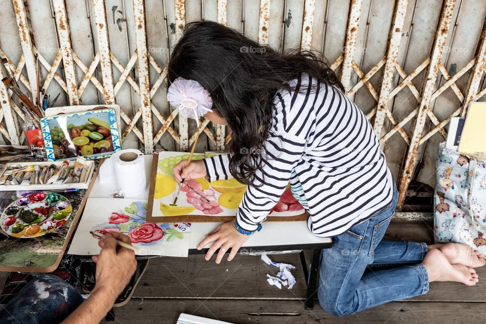 A girl is concentrating her painting in holiday 