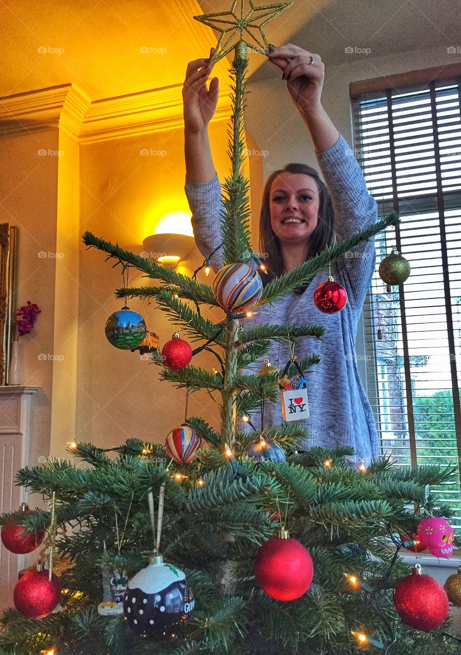 Young woman decorating christmas tree