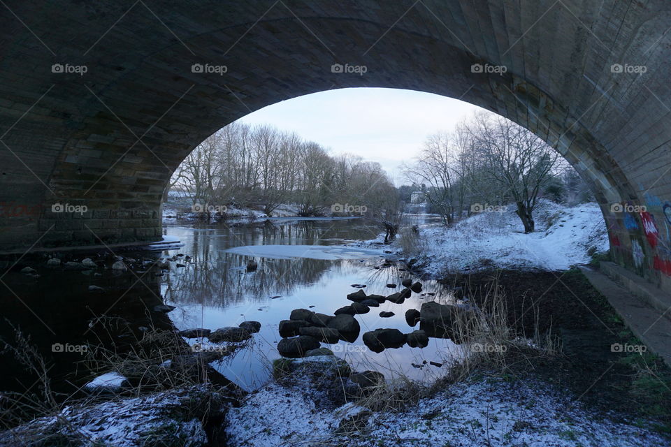 Snowy view through the archway of a bridge ..