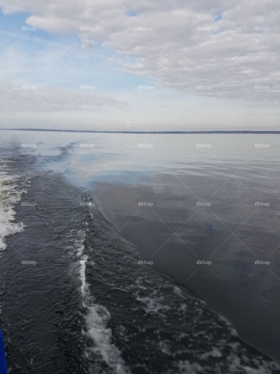 wake behind boat under grey skies