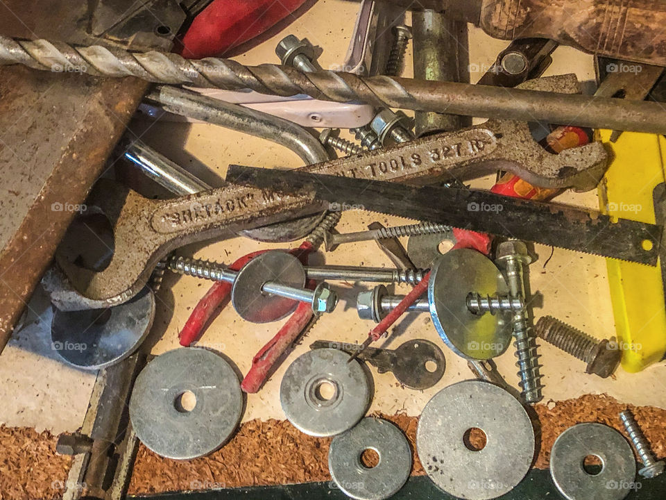 A chaotic mess of metal tools and fixtures on a work bench