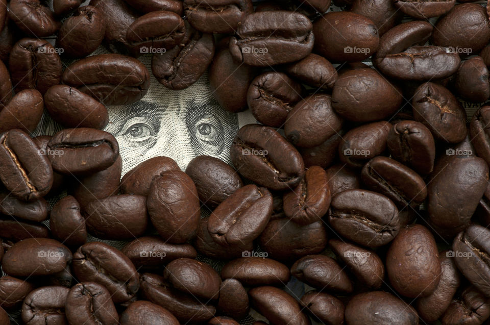 One hunded dollar bill covered with coffee beans