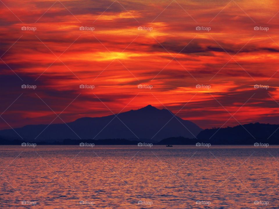 Silhouette of mountain during sunset near sea