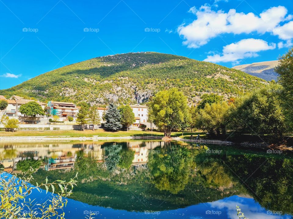 the hill is reflected in the calm lake