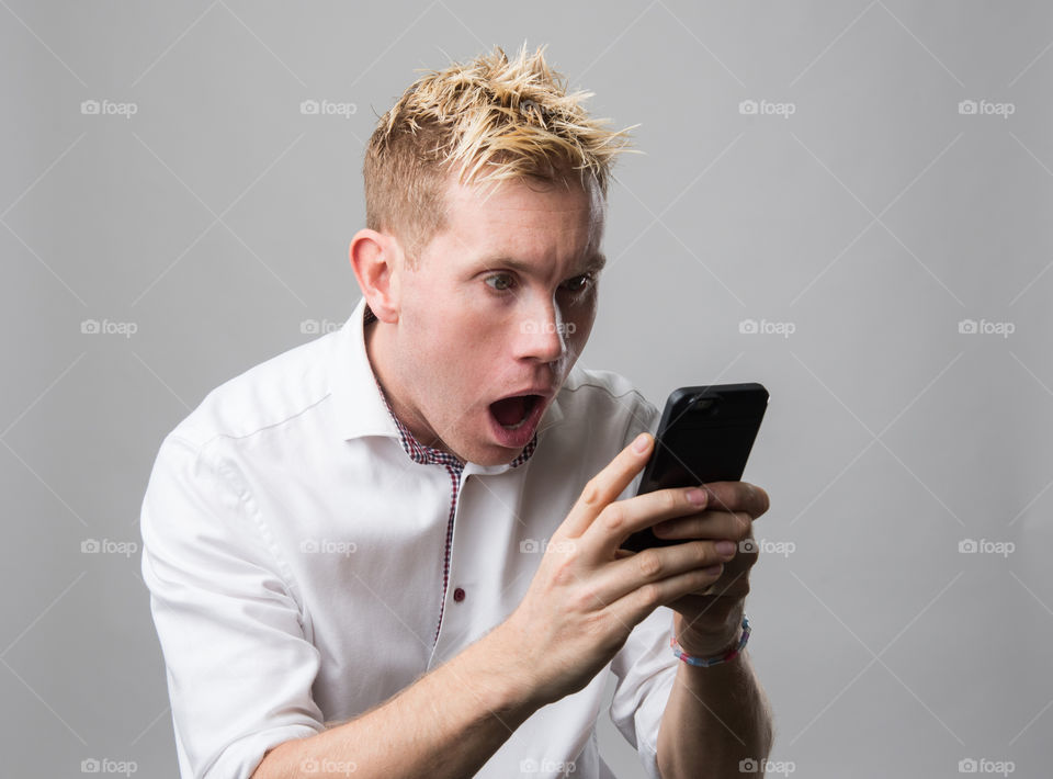 Man with cellular phone with suprised face.