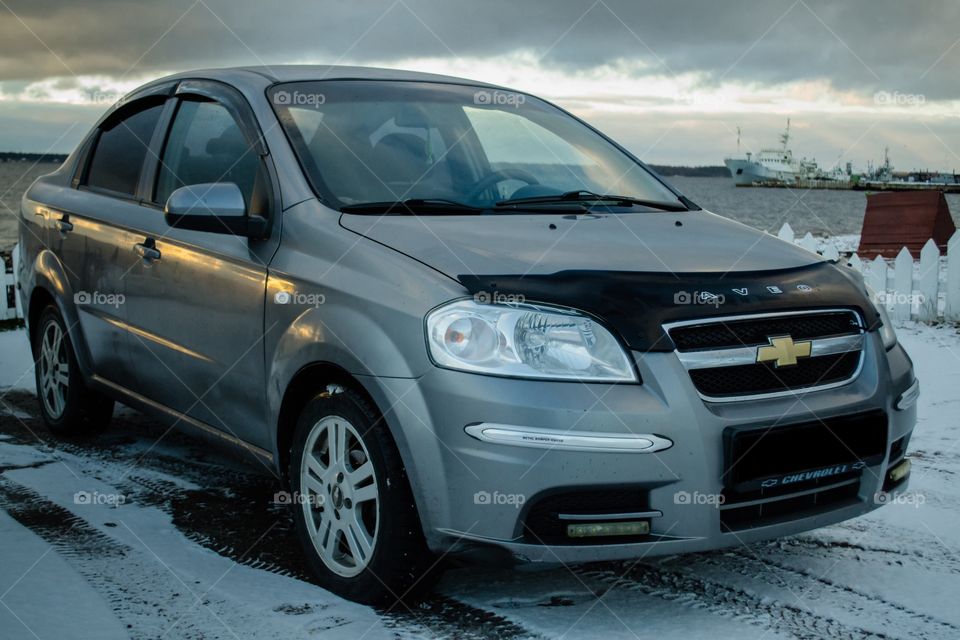 silver Chevrolet Aveo at sunset of the day