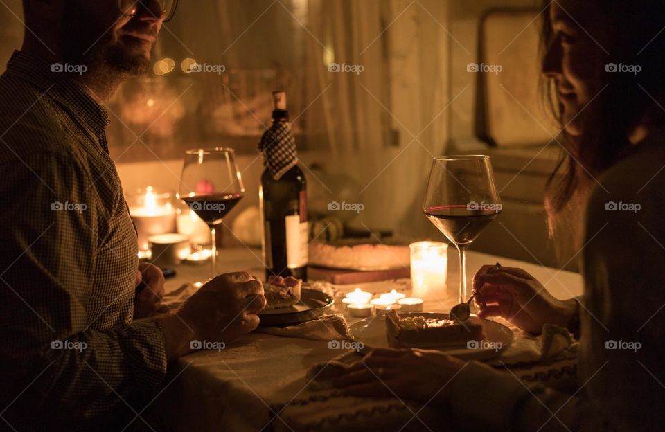 Couple having a romantic dinner at home, at candle light.