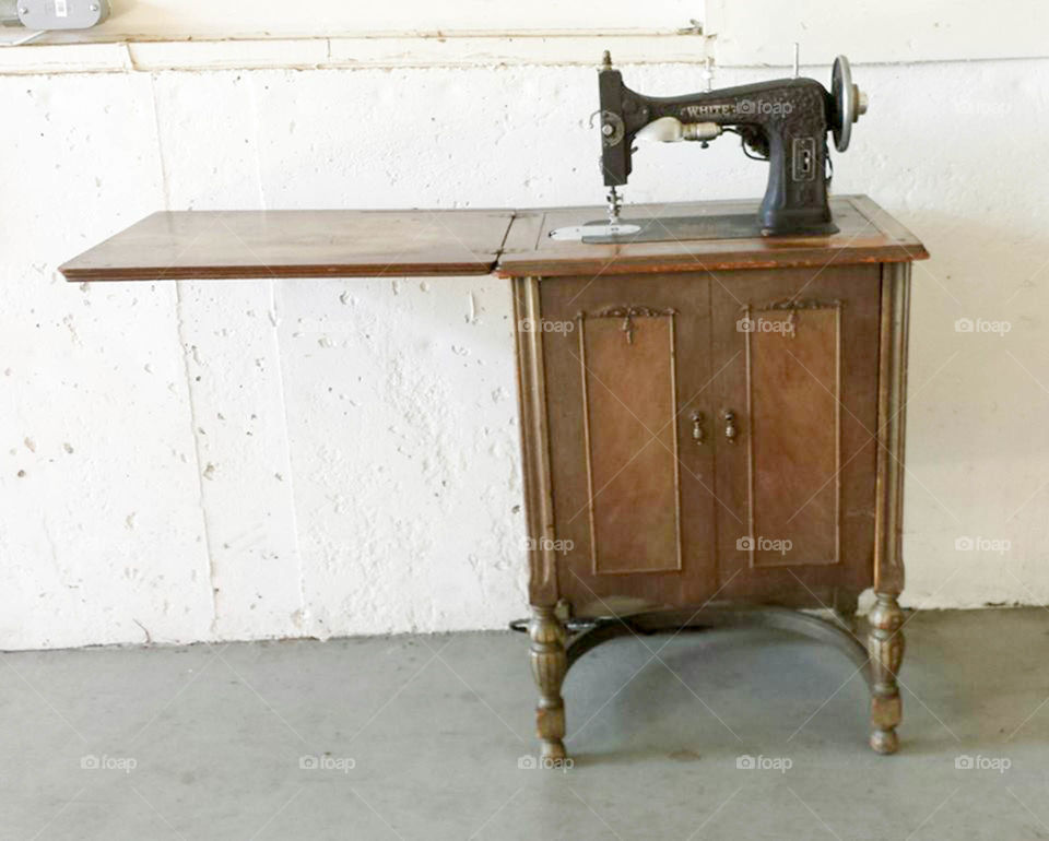 antique sewing cabinet. White brand cast iron sewing machine in wooden cabinet