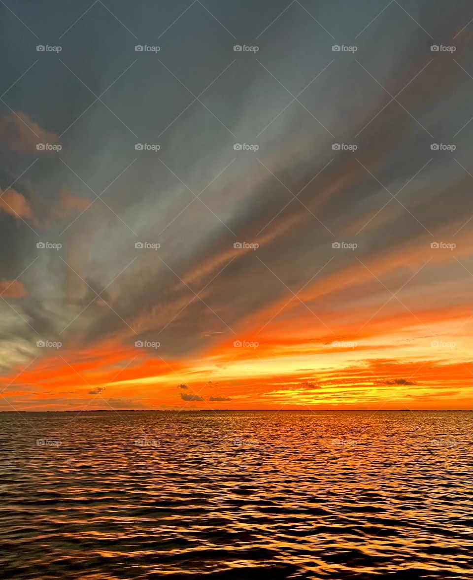 Fiery sunset with billowing clouds from a storm moving in over the bay in Texas 