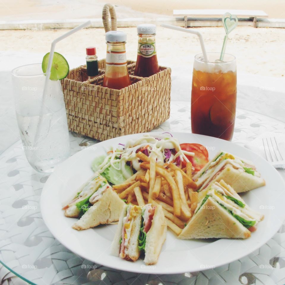 Happy time on the beach . Summer time on the beach with fresh beverages and club sandwiches for lunch