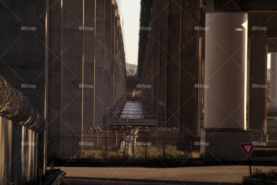 Barb wired fence and concrete pillars make up this highway city down below.