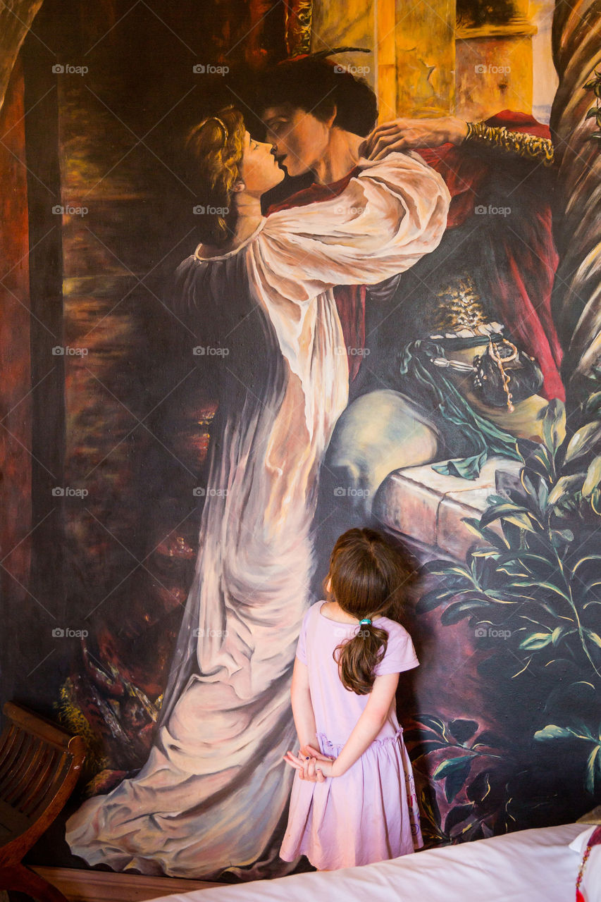Such a sweet moment when my girl admired a fairy tale ending, the happy ever after! 2019 is truly a year of good memories. Image of prince and princess kissing artwork with girl looking up at the art.