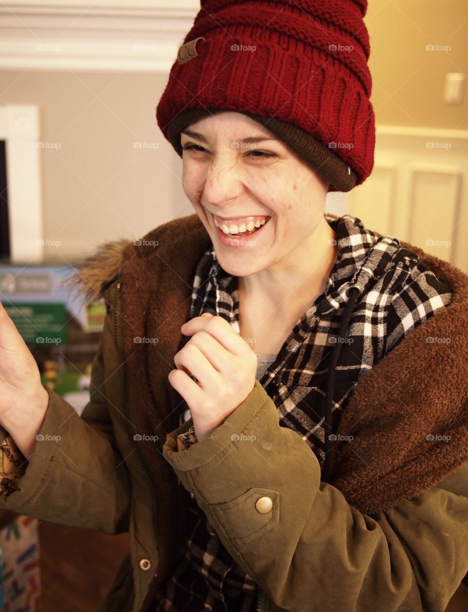 A young lady laughing with great joy over her Christmas present 