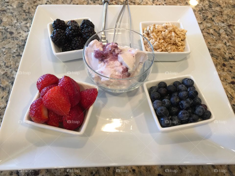 Breakfast parfait. Organic strawberry yogurt with  fresh blueberries blackberries and strawberries with Almond flakes 