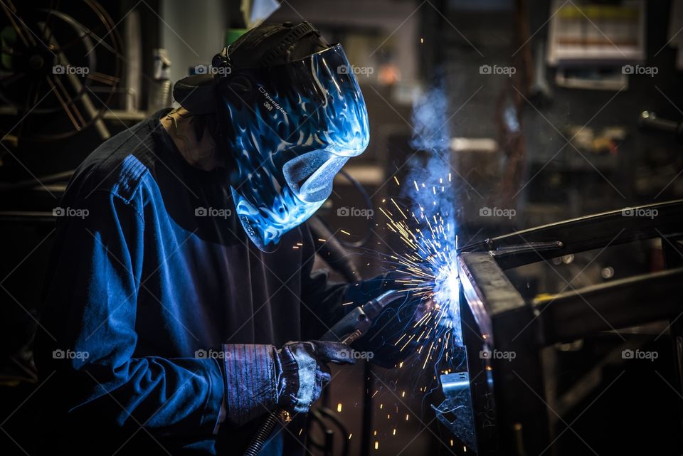 Professional welder working on a heavy equipment Cab for a ROPS cab