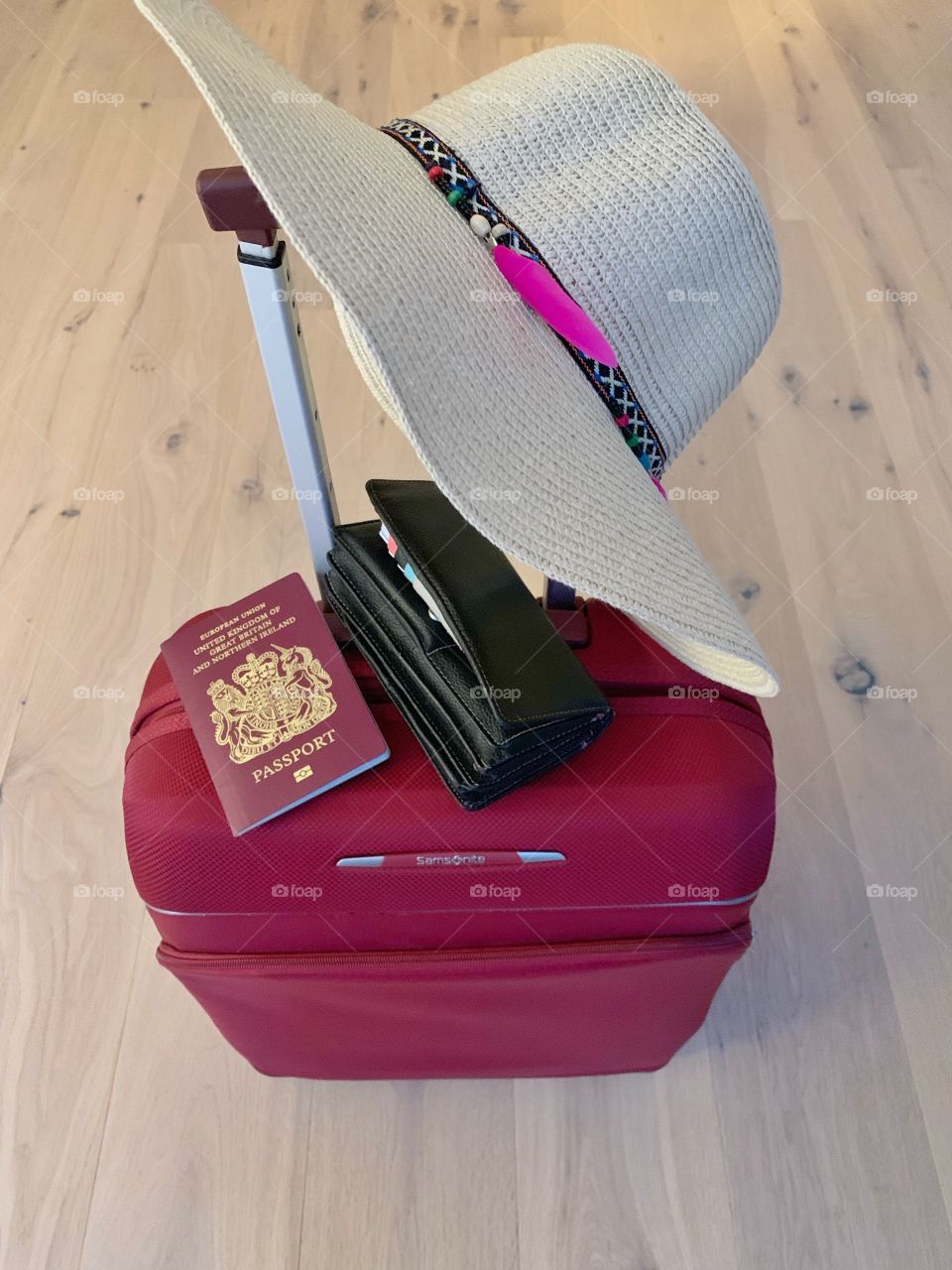 Suitcase with passport, purse and cap