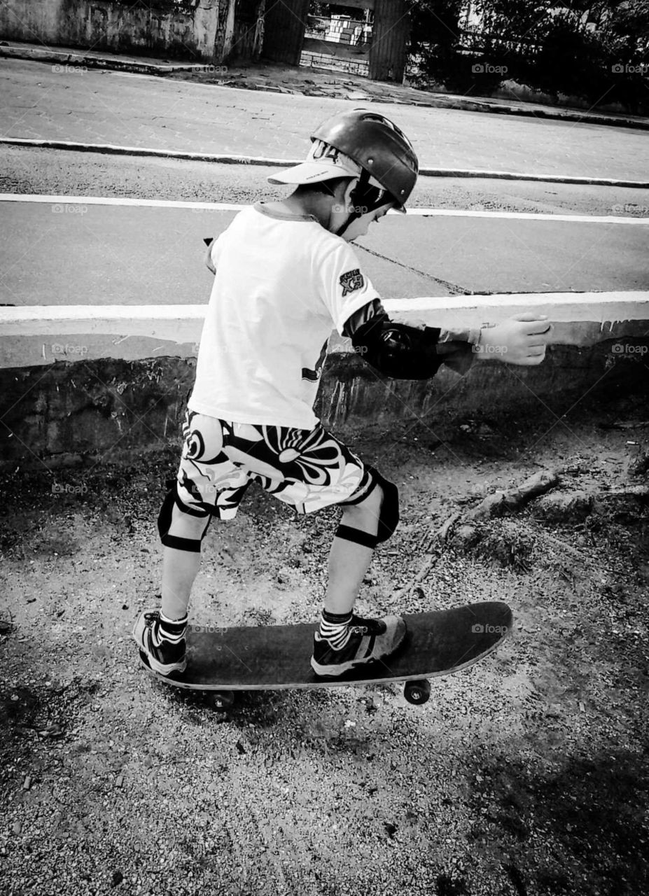 Boy skateboarding in the square in summer black and white photo