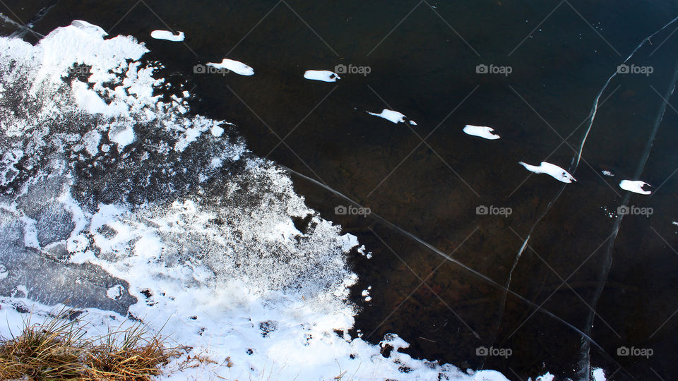 Snowy Footprints Across A Frozen Pond