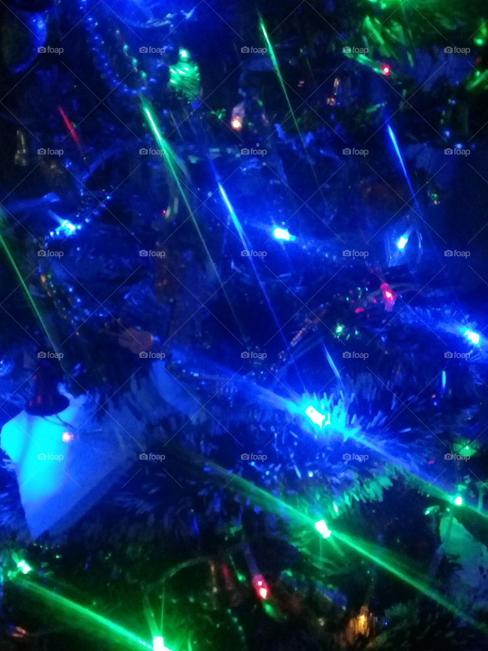 luces navideñas en azul y verde encendidas sobre una pared oscura en una habitación sin iluminación de ningún tipo.