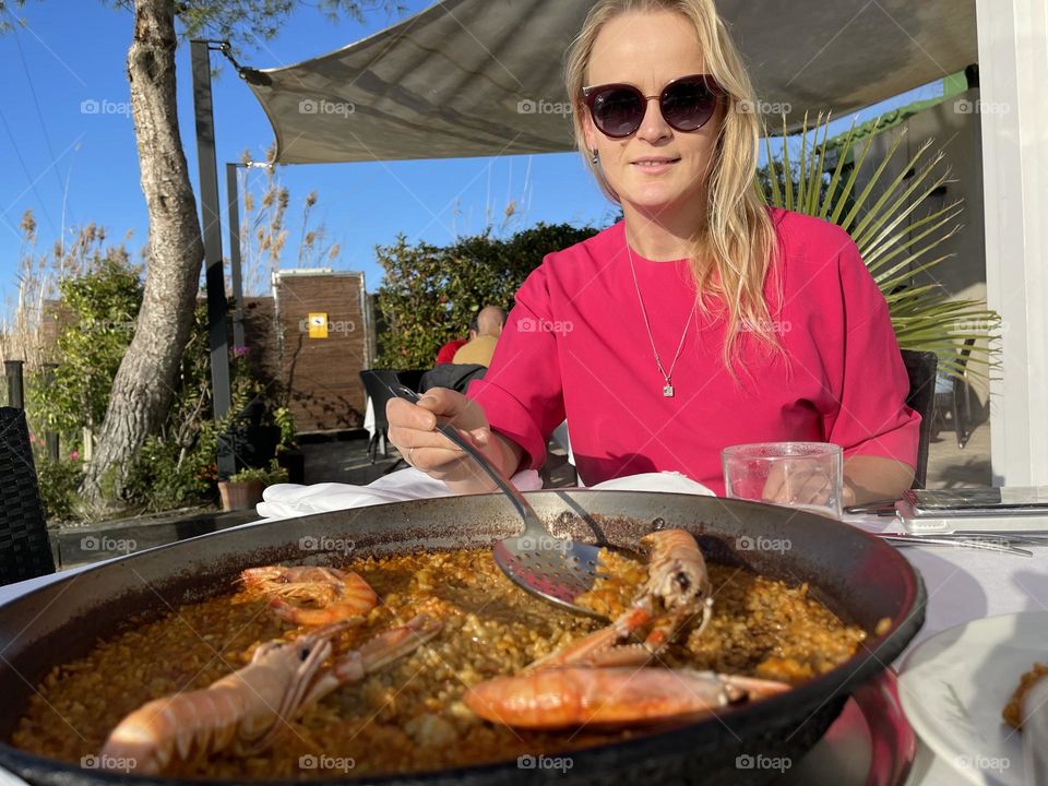 young woman in a restaurant with paella