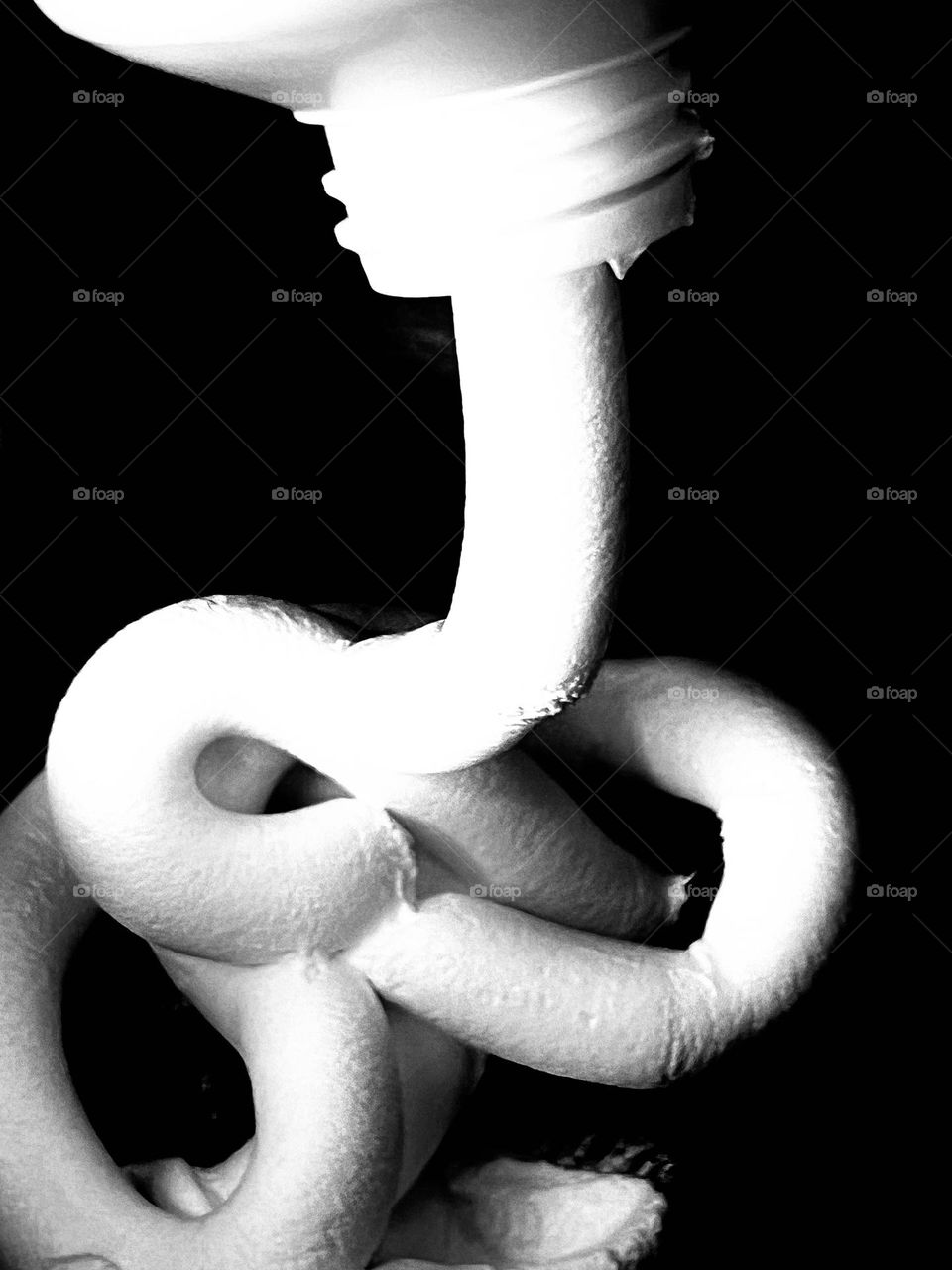 Squeezing cream out of a tube. Close-up. Black and white photo. 