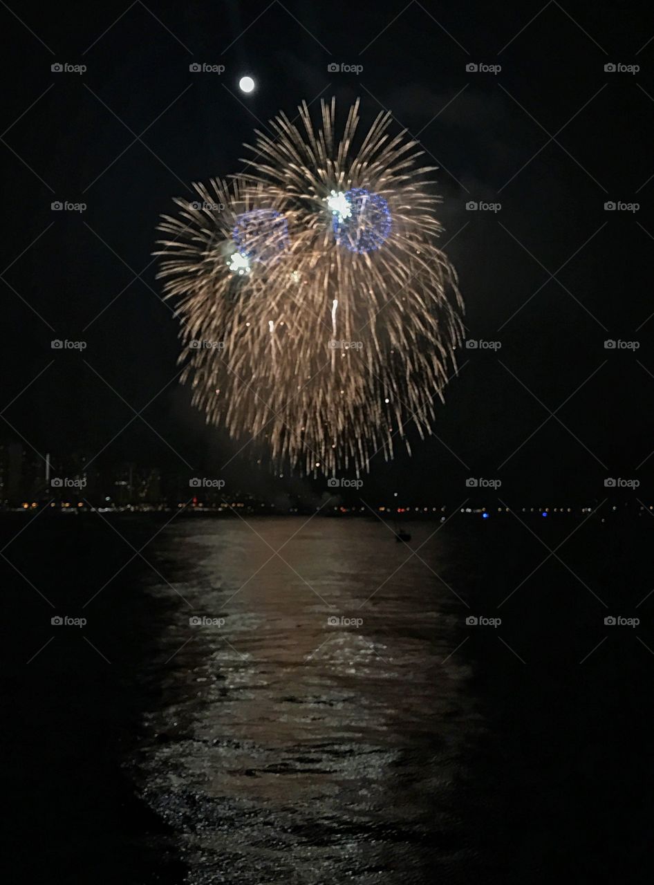 Festival fireworks in Hawaii over the beautiful ocean with the full moon  
